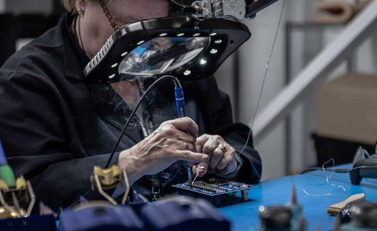 Personne travaillant sur un circuit électronique, illustrant les compétences pratiques de toute entreprise innovante dans le virage numérique et les nouvelles technologies.