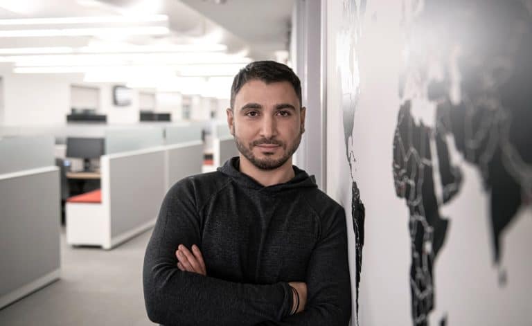 Un entrepreneur lavallois est adossé à un mur avec une carte du monde, symbolisant l'accompagnement de Laval économique du côté des entreprises voulant faire de l'exportation à l'étranger.